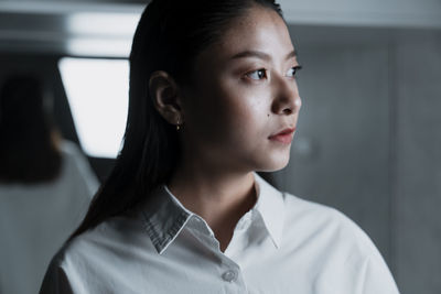 Close-up portrait of a young woman looking away