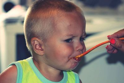 Cropped hand of mother feeding baby boy