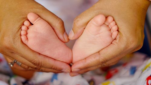 Close-up of father holding baby hand