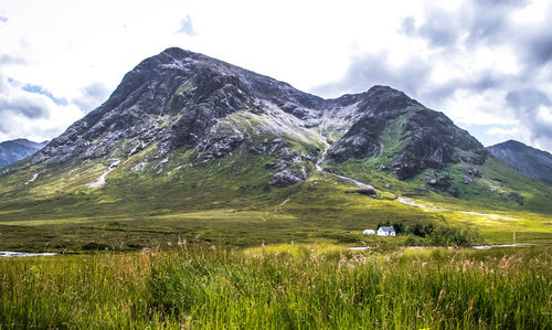 Scenic view of field and mountains against sky