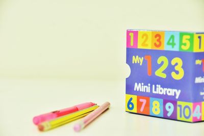 Close-up of multi colored pencils on table against white background