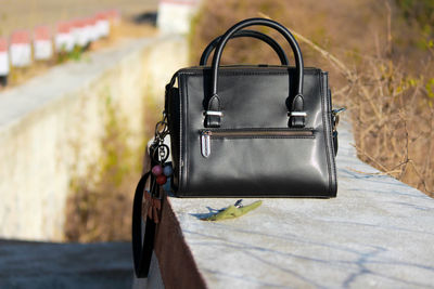 Close-up of purse on retaining wall