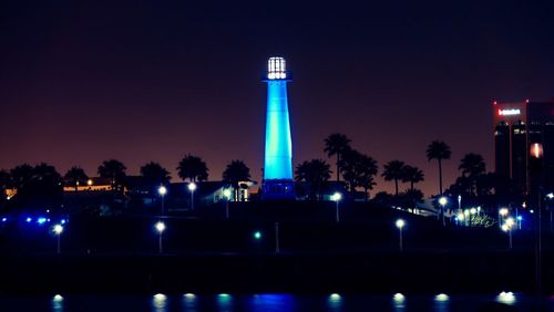 Illuminated blue lighthouse at rainbow harbor