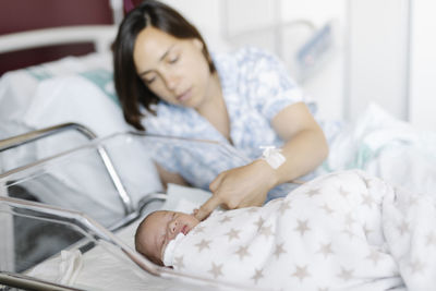 Mother with sleeping newborn kid in hospital