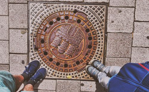 Low section of man standing on tiled floor