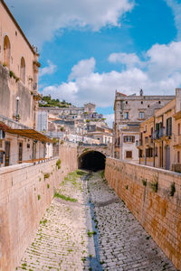 Canal without water in the historic centre of scicli with typical architecture in the background