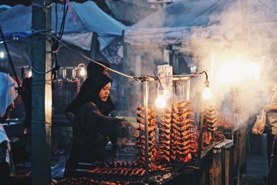 Man in market stall at night