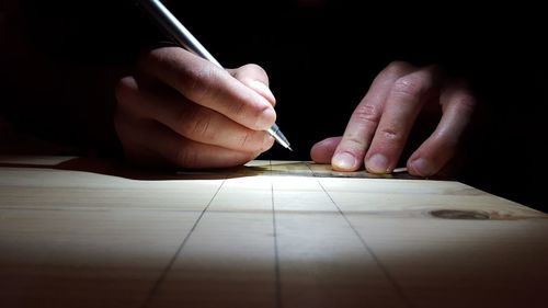 Close-up of hands working on paper