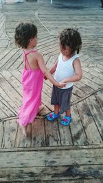 Siblings standing on wood