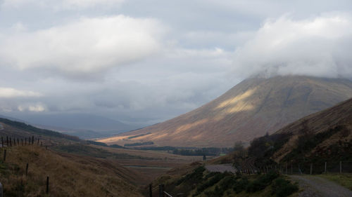 Scenic view of mountains against cloudy sky