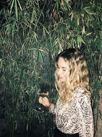 Young woman standing by grass
