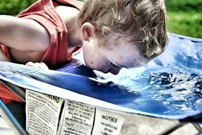 Close-up of toddler drinking water in back yard