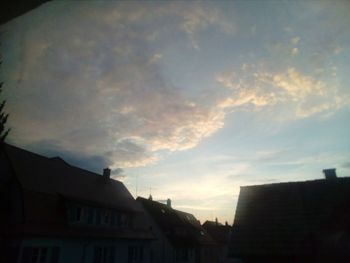 Low angle view of silhouette buildings against sky