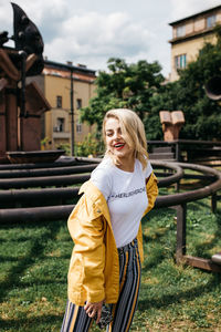 Young woman smiling while standing against plants