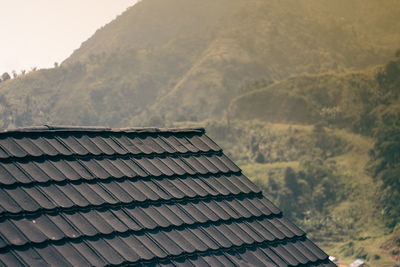 Tilt image of roof of building against mountain