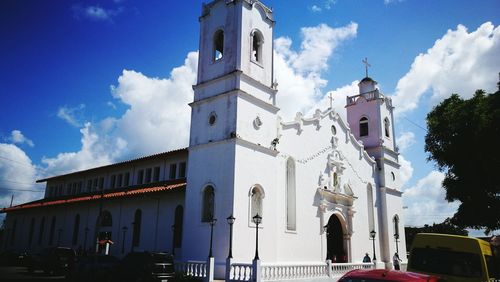 Low angle view of bell tower against cloudy sky