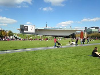 People playing soccer on field against sky