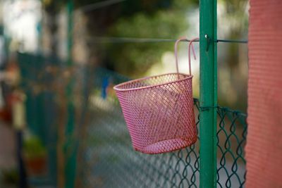 Close-up of wicker basket hanging on metal