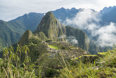 Scenic view of mountain range against cloudy sky