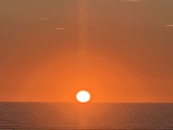 Scenic view of sea against orange sky
