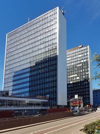 Low angle view of modern buildings against blue sky