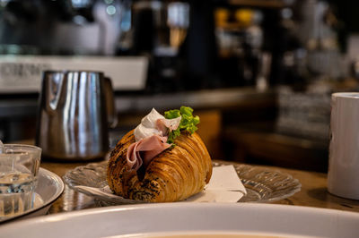 Croissant with ham and cream cheese filling, breakfast in italy