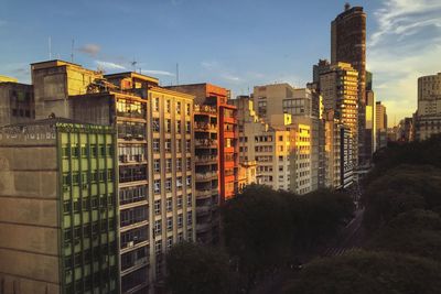 Buildings in city against sky during sunset