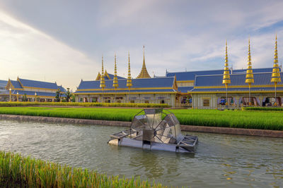 Men in temple by river against sky