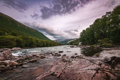 Scenic view of river amidst mountains against sky