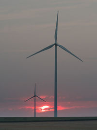 Windmills against sky during sunset
