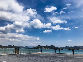 People on beach against sky