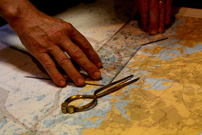 Cropped hands measuring map at home