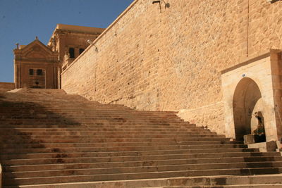 Low angle view of staircase by building against sky