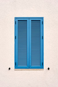 Blue window on wall of building