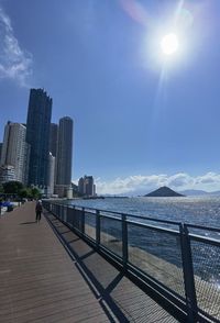 Sea by buildings against sky in city