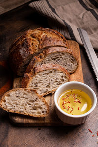 Freshlybaked bread with olive oil on a wooden board