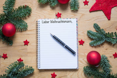 Directly above view of pen and notepad amidst christmas decoration on table