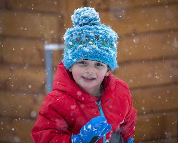 Portrait of cute boy in warm clothing during snowfall