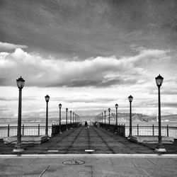 View of street lights against cloudy sky