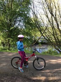 Rear view of boy riding bicycle on road