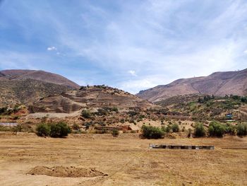 Scenic view of field and mountains against sky