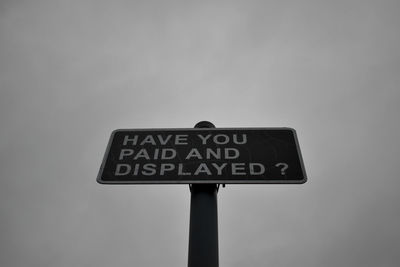 Low angle view of information sign against sky