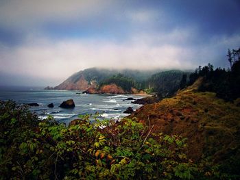 Scenic view of sea and mountains against sky