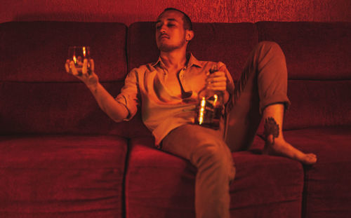 Portrait of young woman using laptop while sitting on sofa at home