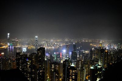 Illuminated cityscape against sky at night