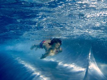 Shirtless boy swimming in pool