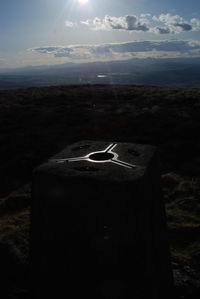 Close-up of umbrella on land against sky during sunset