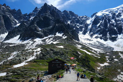 People on snowcapped mountain against sky