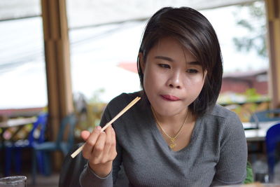 Woman looking down while having food in restaurant