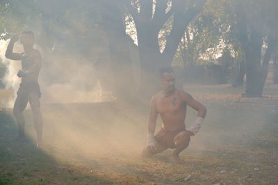 Full length of shirtless man standing on field